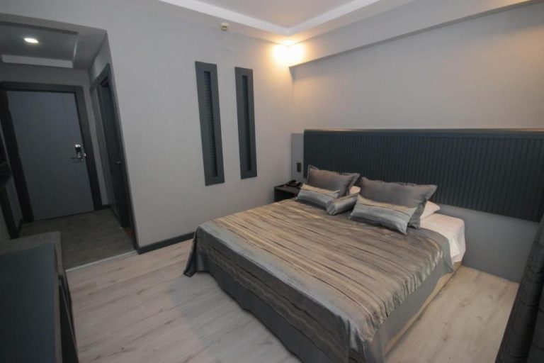 Habitación doble de lujo con cama king size y cabecero tapizado en el Mostar Hotel Antalya