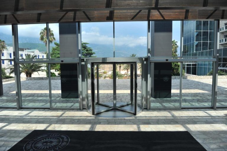 Entrada principal con puerta giratoria y fachada de cristal del Avala Resort & Villas