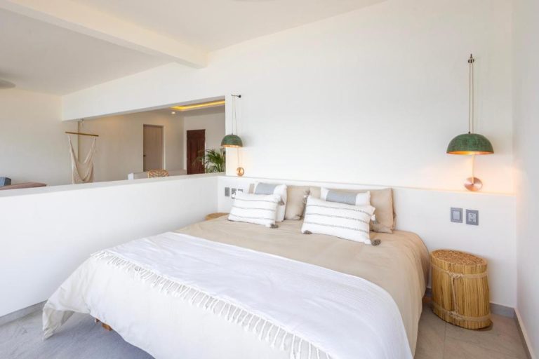 Habitación doble con cama king y decoración boho chic en tonos blancos y naturales del Cabo Break Hotel