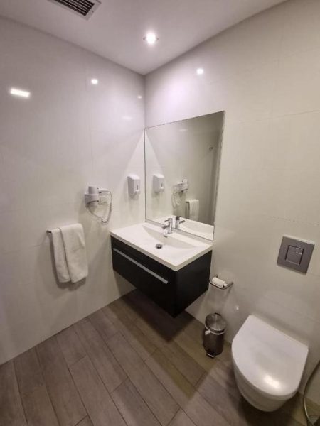 Baño moderno con lavabo suspendido, espejo y WC en Casa do Adro Hotel de Charme