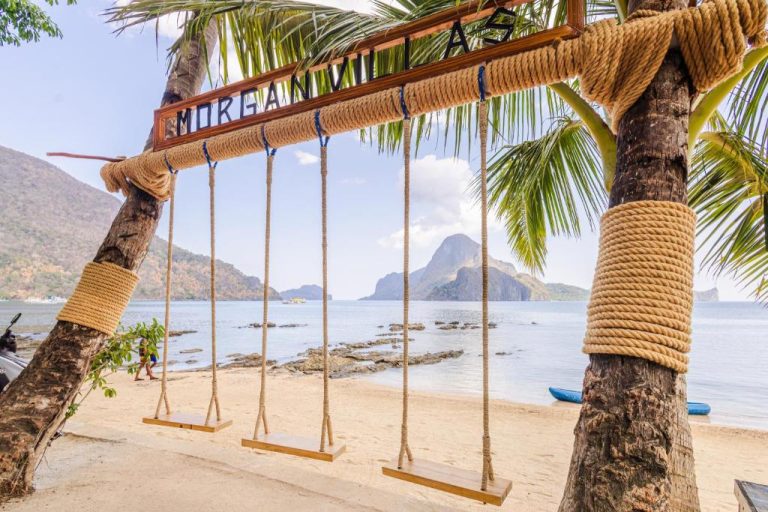Columpios de madera con vistas al mar y montañas en la playa de Morgan Villas El Nido