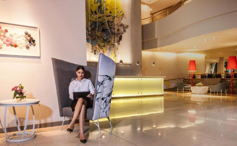 Elegante lobby del Hennessy Park Hotel con recepción iluminada y zona de descanso contemporánea