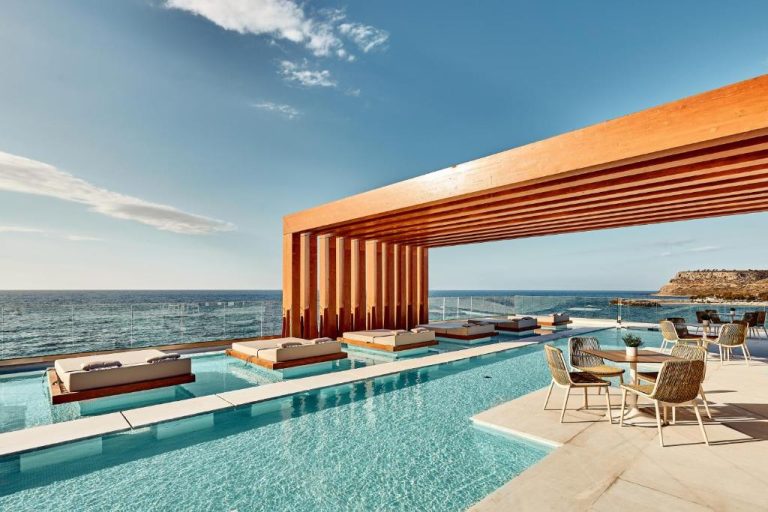 Piscina infinita con camas flotantes y pérgola de madera en Enorme Santanna Island con vistas al mar