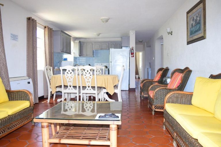 Sala de estar con muebles de ratán y comedor integrado con cocina en Best E Villas Prospect St James
