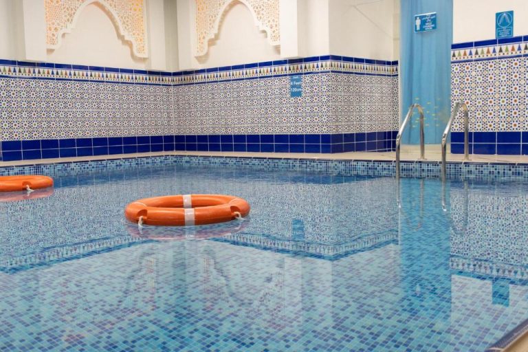 Piscina interior con azulejos decorativos y aros salvavidas del Central Inn Souq Waqif en Doha