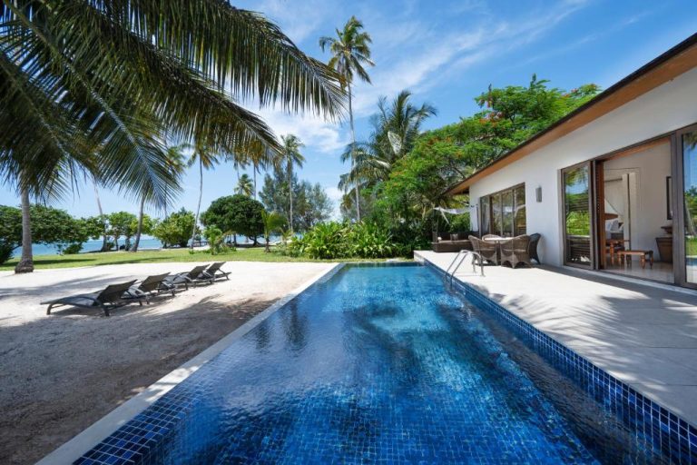 Piscina privada con vistas a la playa de arena blanca y palmeras en The Residence Zanzibar