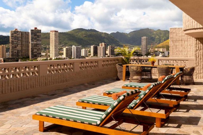 Terraza con tumbonas y vistas panorámicas de Honolulu en el Wayfinder Waikiki Hotel en Hawái