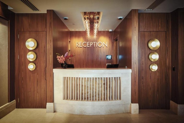 Recepción elegante con mostrador de mármol y paneles de madera en Grand Galata Hotel & Spa