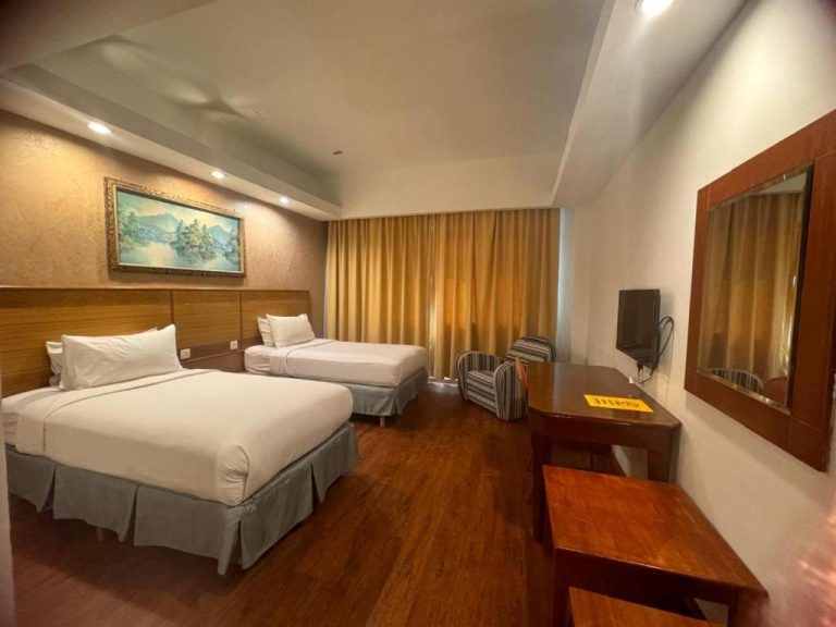 Habitación twin con dos camas y escritorio de madera en Mayres Hotel, suelo de parqué