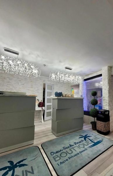 Recepción moderna del Ocean Sands Beach Boutique Inn con lámparas de cristal y alfombras decorativas