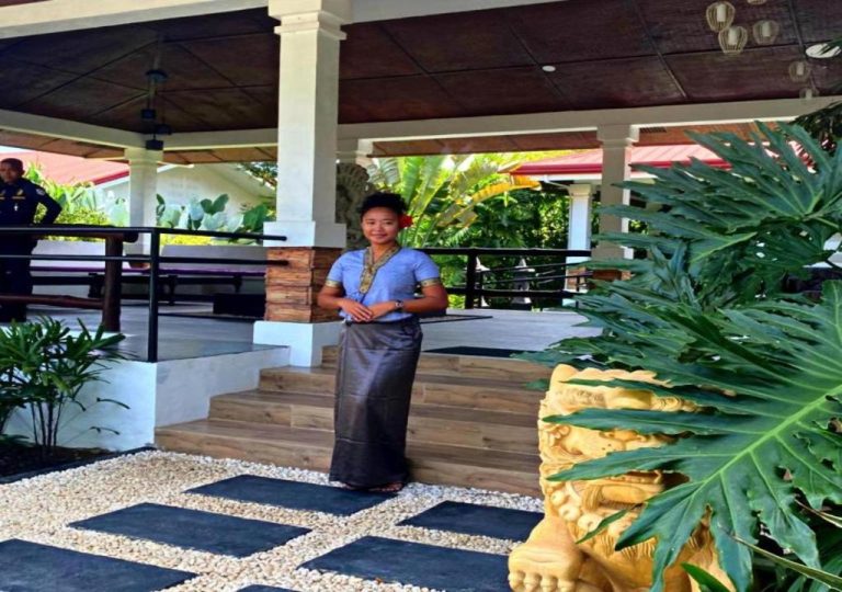 Recepcionista en traje tradicional dando la bienvenida en la entrada del Carpe Diem Villas & Resort