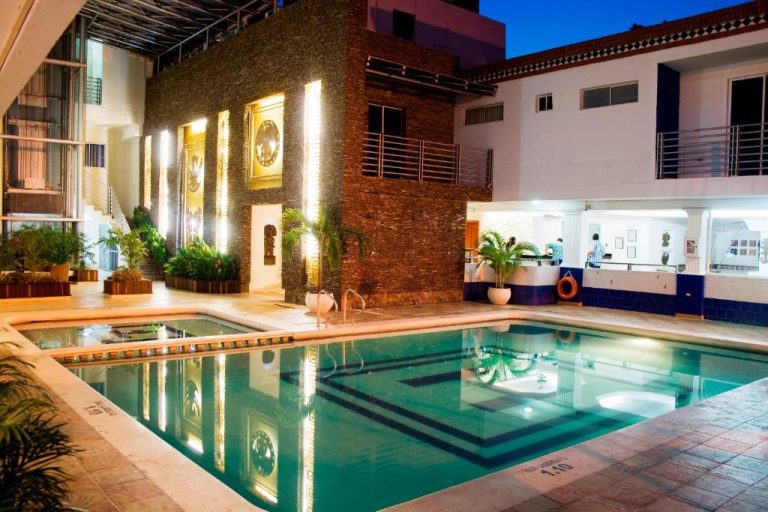Piscina interior iluminada del Hotel Tayrona Rodadero con jacuzzi y barra de bar al fondo