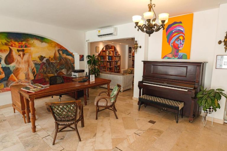 Lobby del Hotel Kartaxa con piano clásico, murales artísticos y biblioteca en Cartagena de Indias