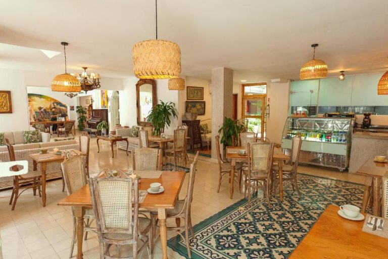 Restaurante interior del Hotel Kartaxa con mesas de madera, sillas de mimbre y vitrina de buffet