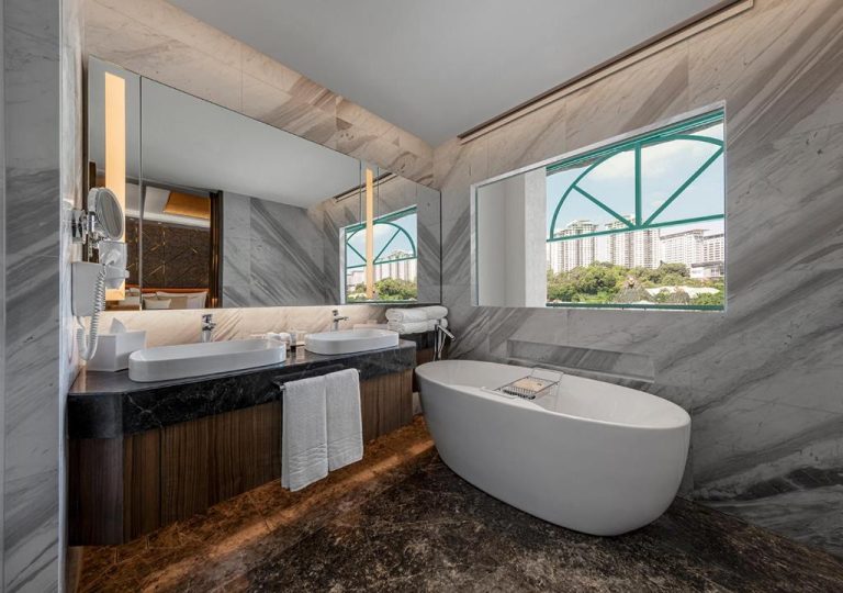 Baño de lujo con bañera exenta y doble lavabo en mármol del Sunway Resort Hotel con vistas a la ciudad