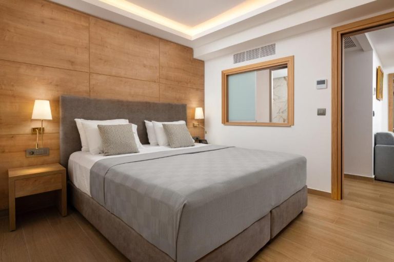 Habitación doble con cama king size y pared de madera en Acandia Hotel