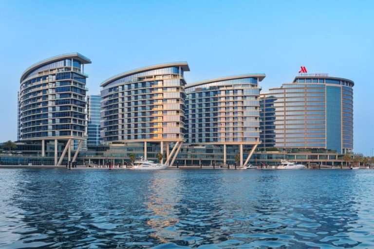 Vista panorámica del Marriott Marquis City Center Dubai Creek desde el mar con yates y fachada moderna