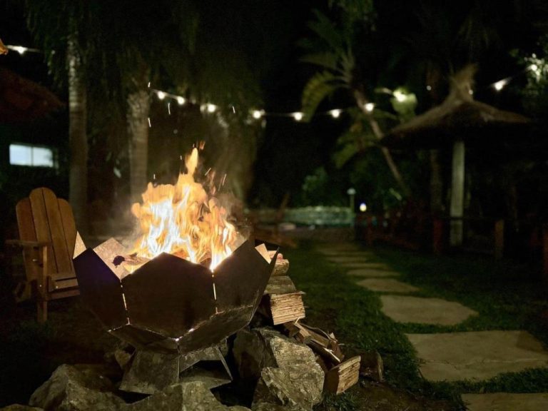 Fogata exterior con leños en jardín nocturno del hotel Dunas del Este Punta Colorada