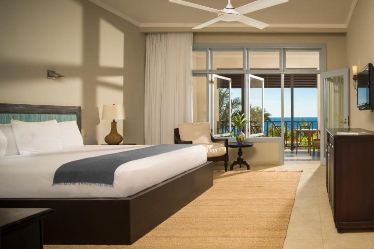 Habitación de lujo con cama king size y balcón con vistas al mar en The Cliff Hotel