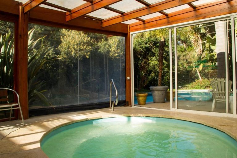 Jacuzzi interior cubierto con estructura de madera y vistas al jardín en Dunas del Este Punta Colorada