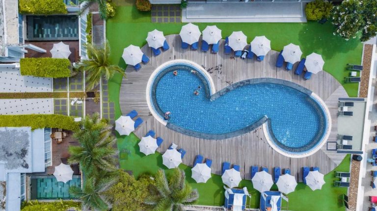 Vista aérea de la piscina exterior con forma de yin yang del KC Beach Hotel Samui con tumbonas