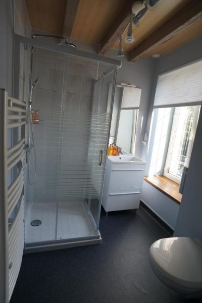 Baño moderno con ducha acristalada y lavabo en el Moulin de Petoulle