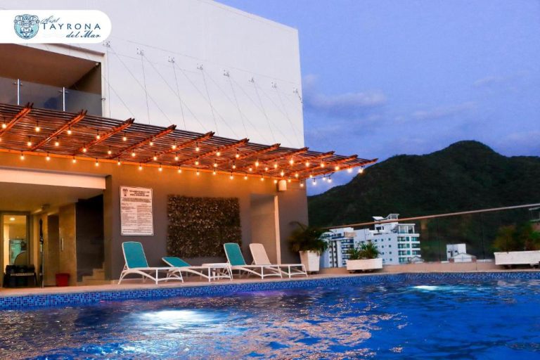 Piscina exterior con terraza iluminada y tumbonas del Hotel Tayrona del Mar al atardecer