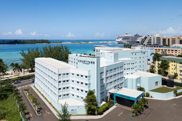 Vista aérea del Courtyard by Marriott Nassau Downtown con playa y crucero al fondo en Bahamas