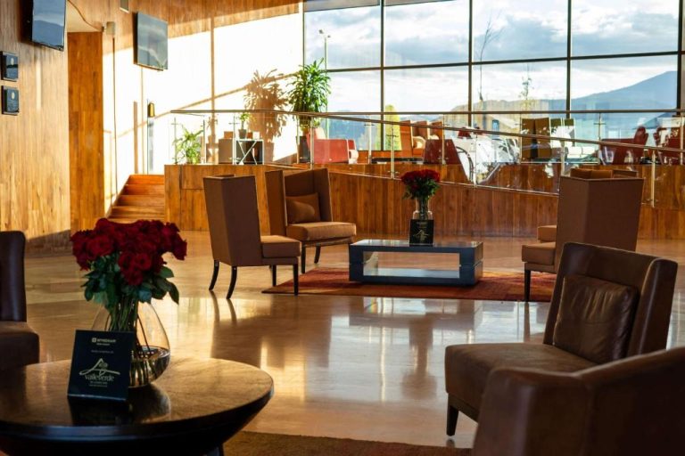 Elegante lobby con sala de espera y flores rojas en el Hotel Wyndham Quito Airport
