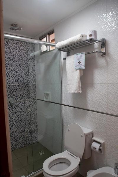 Baño moderno con ducha de cristal y toallas en Hotel FK Paso de los Toros Hotel Boutique