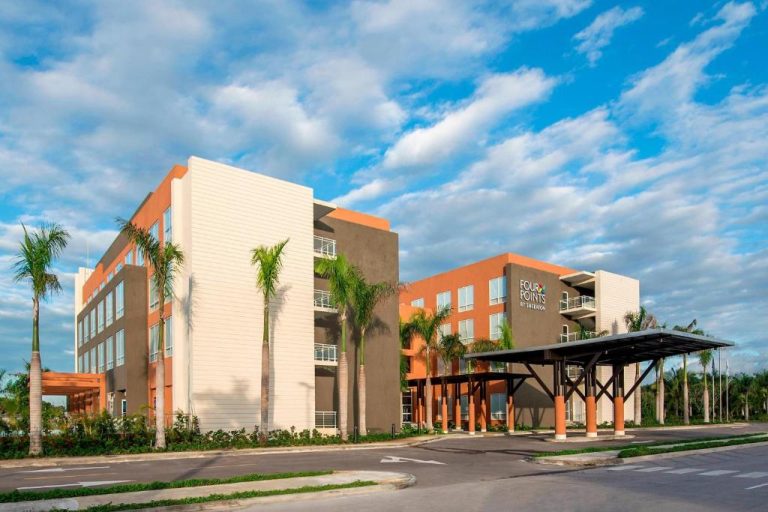 Fachada exterior del hotel Four Points by Sheraton Puntacana con palmeras y entrada principal