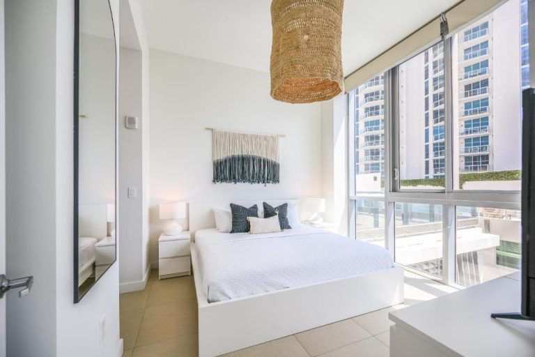 Habitación doble luminosa con cama blanca y vistas a los rascacielos en Monte Carlo by Miami Vacations