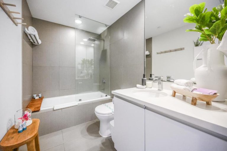 Baño completo moderno con bañera y ducha de cristal en Monte Carlo by Miami Vacations
