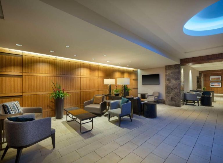 Elegante lobby lounge del Hilton Indianapolis Hotel & Suites con sillones modernos y paredes de madera