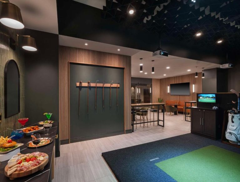 Simulador de golf interior con zona de snacks y cócteles en el Hilton Indianapolis Hotel & Suites