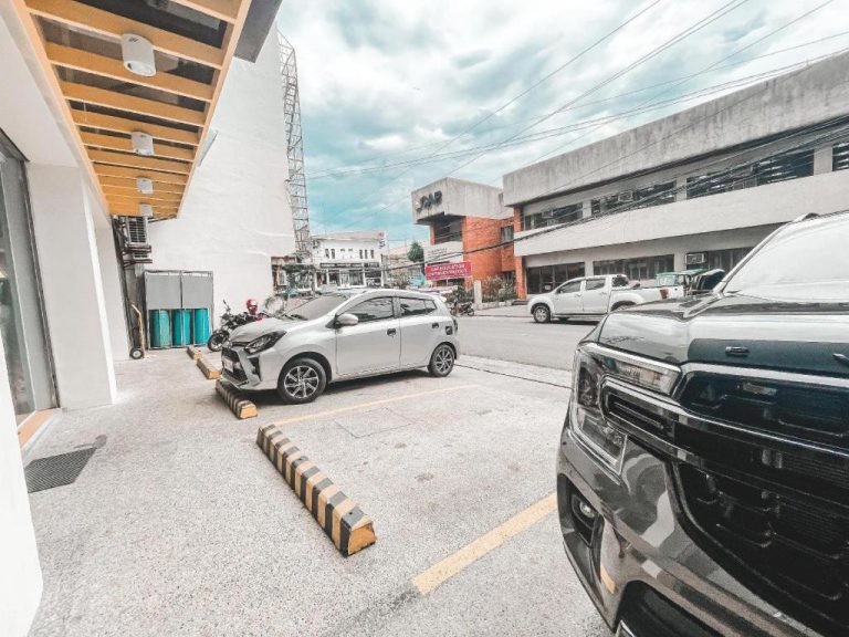 Área de estacionamiento exterior del Lavero Suites con espacios para vehículos y acceso principal