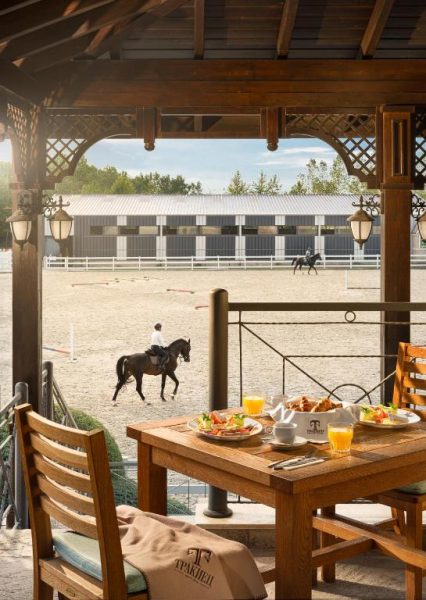 Terraza con desayuno y vistas al picadero ecuestre del Boutique Complex Trakiets
