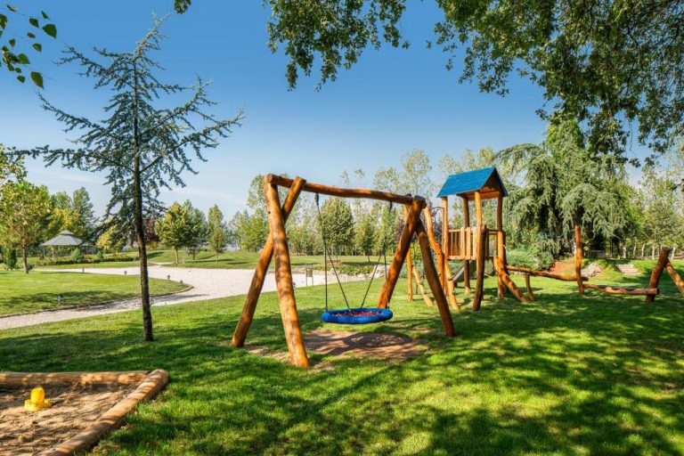 Zona de juegos infantil con columpios y toboganes de madera en Boutique Complex Trakiets