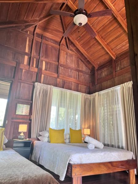 Habitación rústica con techo de madera y camas dobles en Hotel Villas de la Colina