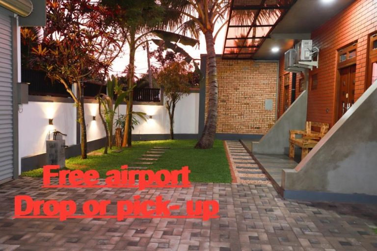 Jardín exterior iluminado con palmeras y servicio gratuito de traslado al aeropuerto en Airport Colombo Pocket Paradise