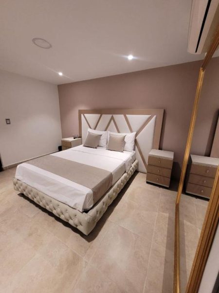 Habitación doble de lujo con cama king size y cabecero elegante en Hotel Med 33