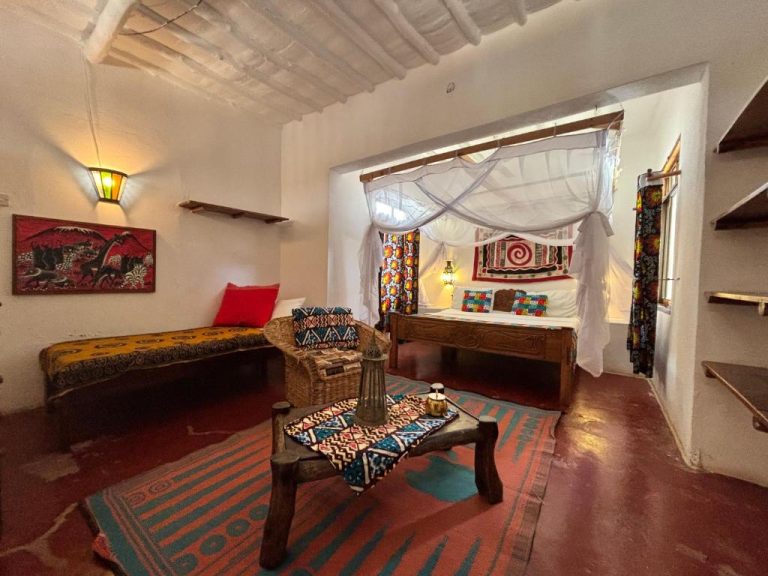 Habitación con cama de dosel y decoración africana tradicional en Sawa Sawa Beach House