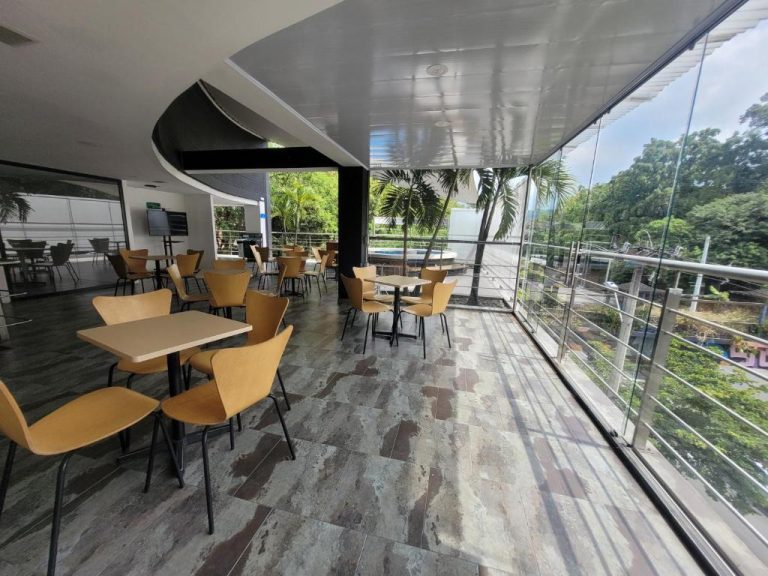 Restaurante con terraza panorámica y vistas al jardín en Hotel Med 33, con mesas y sillas modernas