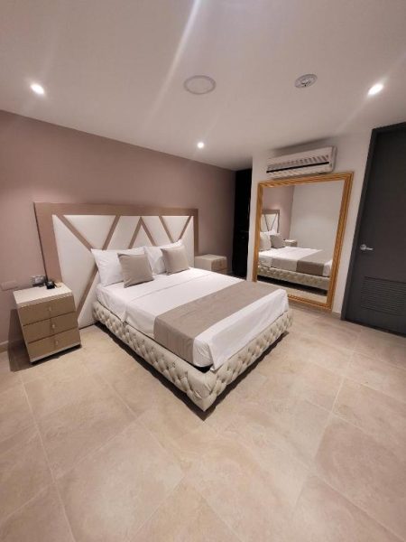 Habitación doble de lujo con cama king size y espejo decorativo en Hotel Med 33