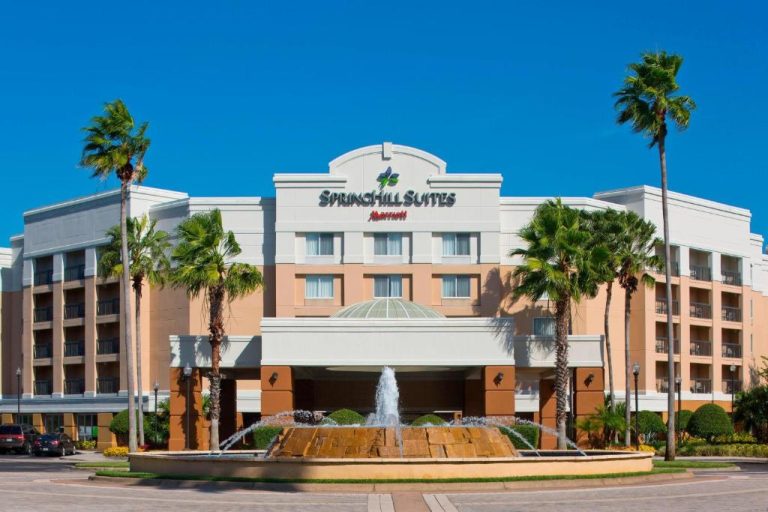 Fachada principal del SpringHill Suites Marriott Orlando Lake Buena Vista con fuente y palmeras