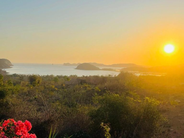 Espectacular puesta de sol sobre la bahía de Lobster Bay Lombok con vegetación tropical y flores de buganvilla