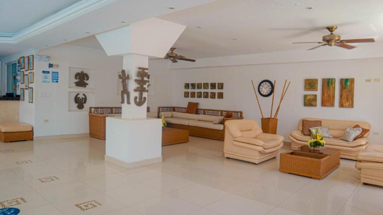 Amplio lobby del Hotel Tayrona Rodadero con sofás de cuero, arte precolombino y ventiladores de techo