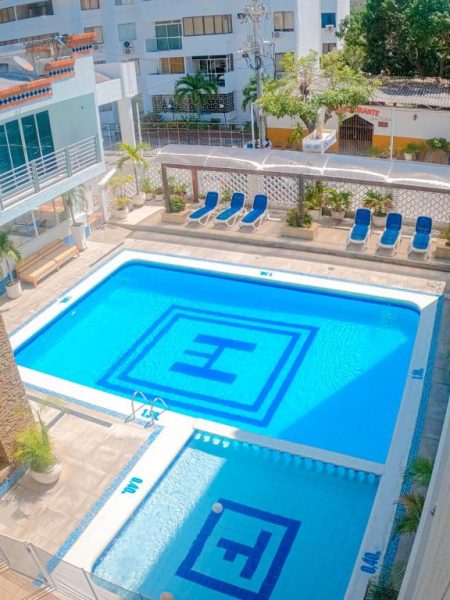 Piscina exterior con tumbonas azules y área de descanso del Hotel Tayrona Rodadero en Santa Marta