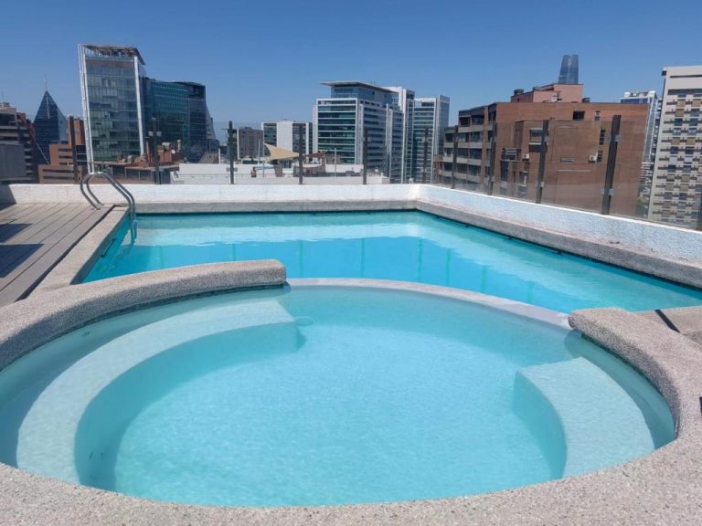 Piscina rooftop con jacuzzi y vistas al skyline de Santiago en Apart Barrio El Golf