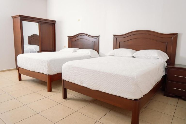 Habitación doble con dos camas individuales y mobiliario de madera en Hotel Real Paraiso